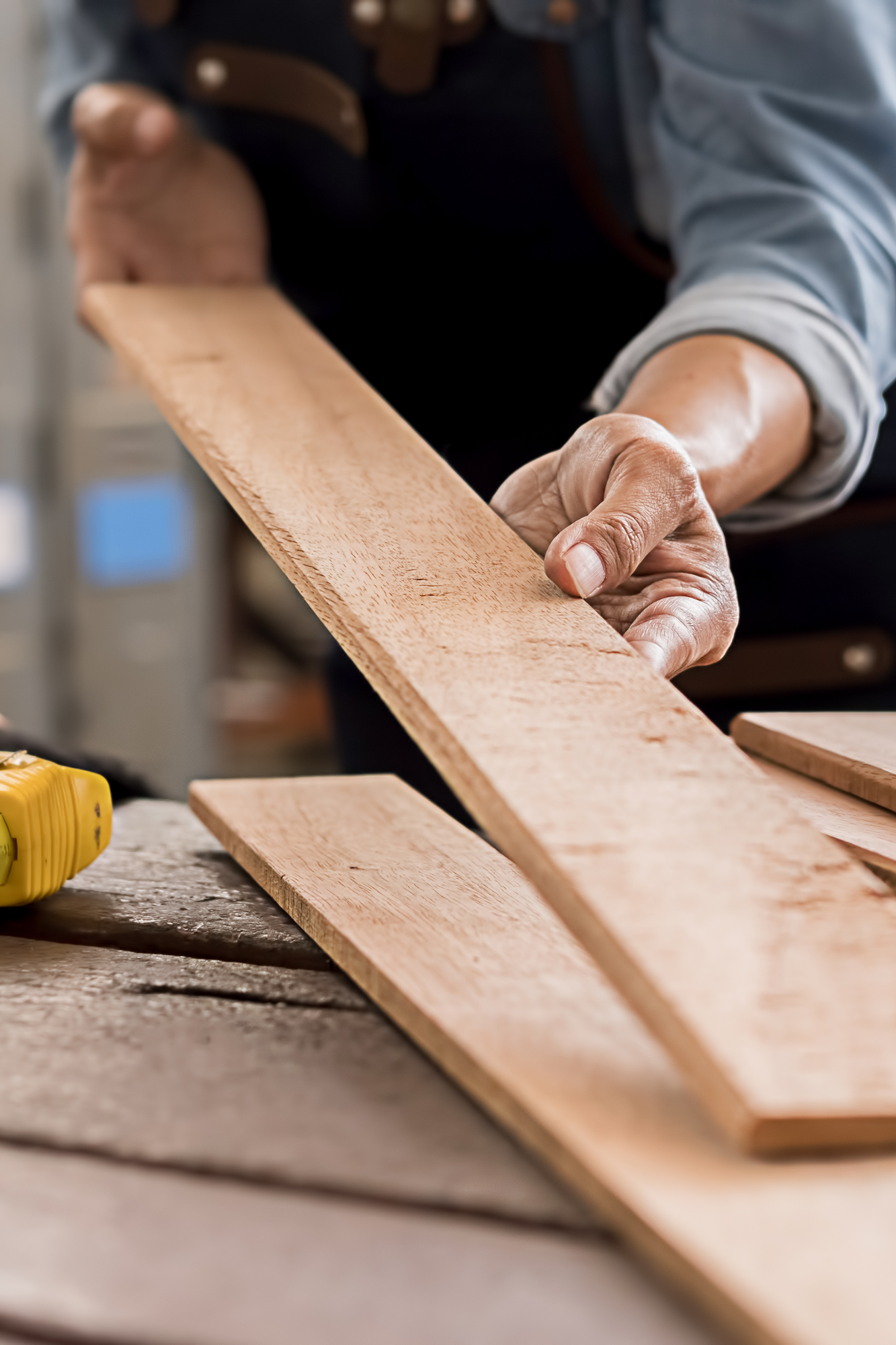 A person working with wood on a table.