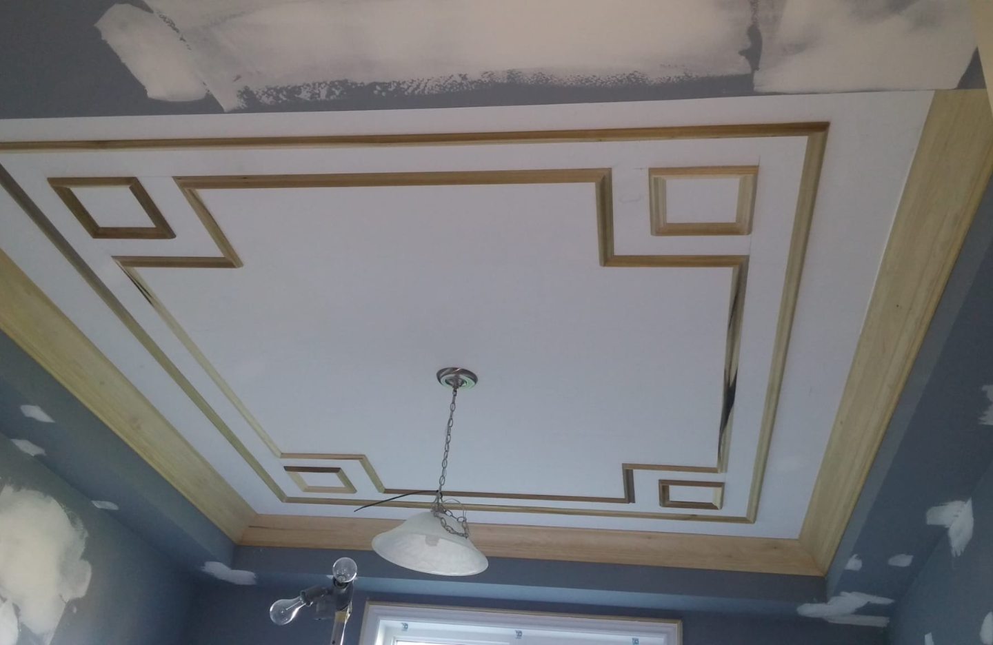 A room with a ceiling that is being painted.